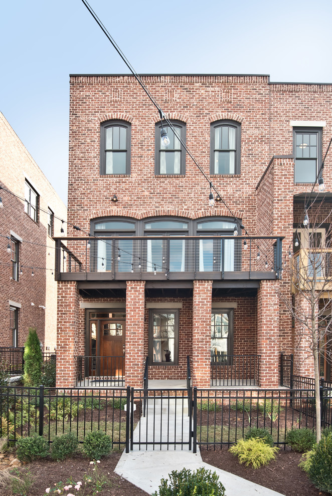 Photo of an industrial three-storey brick red townhouse exterior in Atlanta with a flat roof.