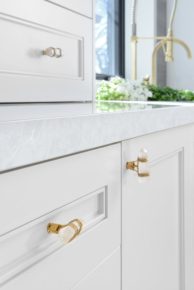Example of a mid-sized transitional u-shaped light wood floor and gray floor open concept kitchen design in Toronto with an undermount sink, shaker cabinets, white cabinets, solid surface countertops, stainless steel appliances and an island