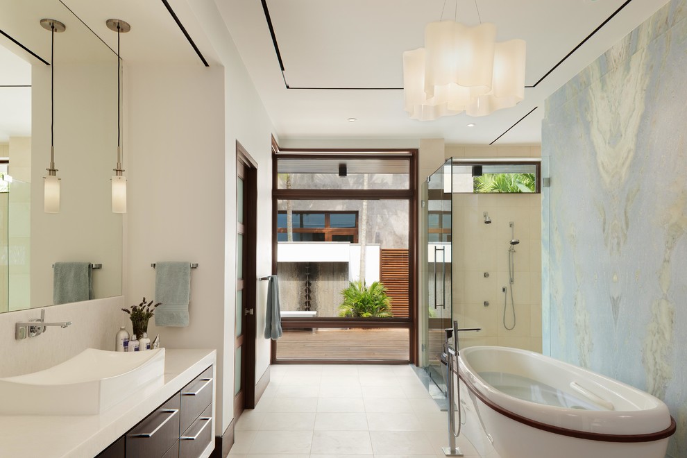 This is an example of a contemporary master bathroom in Miami with flat-panel cabinets, dark wood cabinets, a freestanding tub, a double shower, multi-coloured tile, white walls, a vessel sink and white floor.