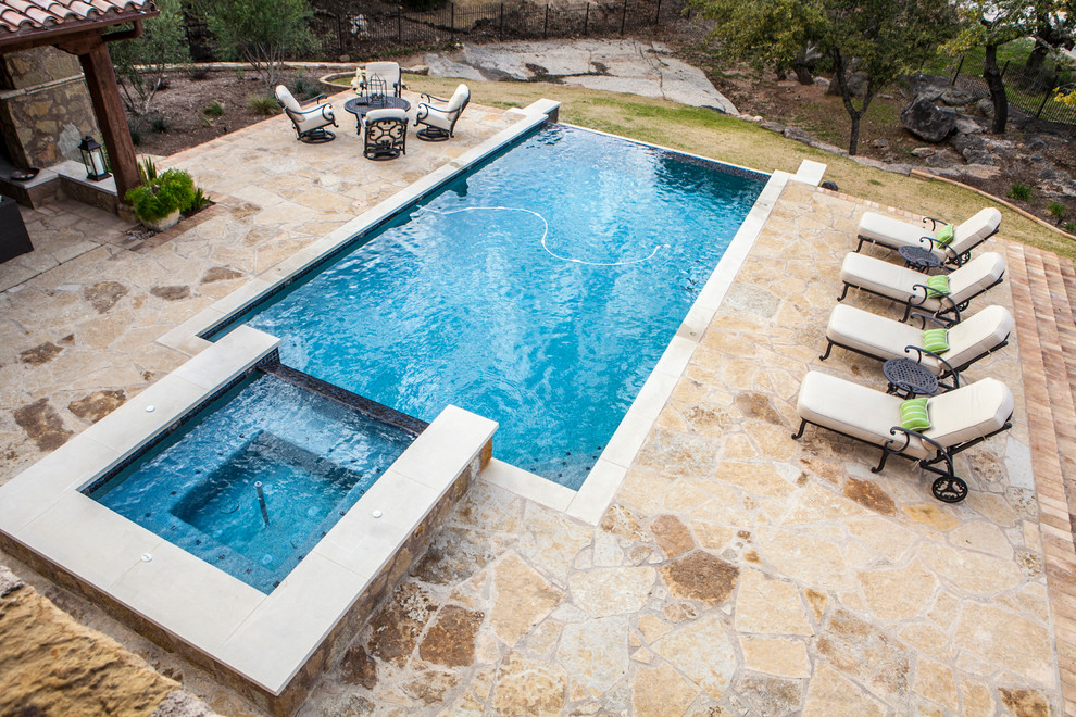 Mid-sized transitional backyard stone and rectangular lap hot tub photo in Austin