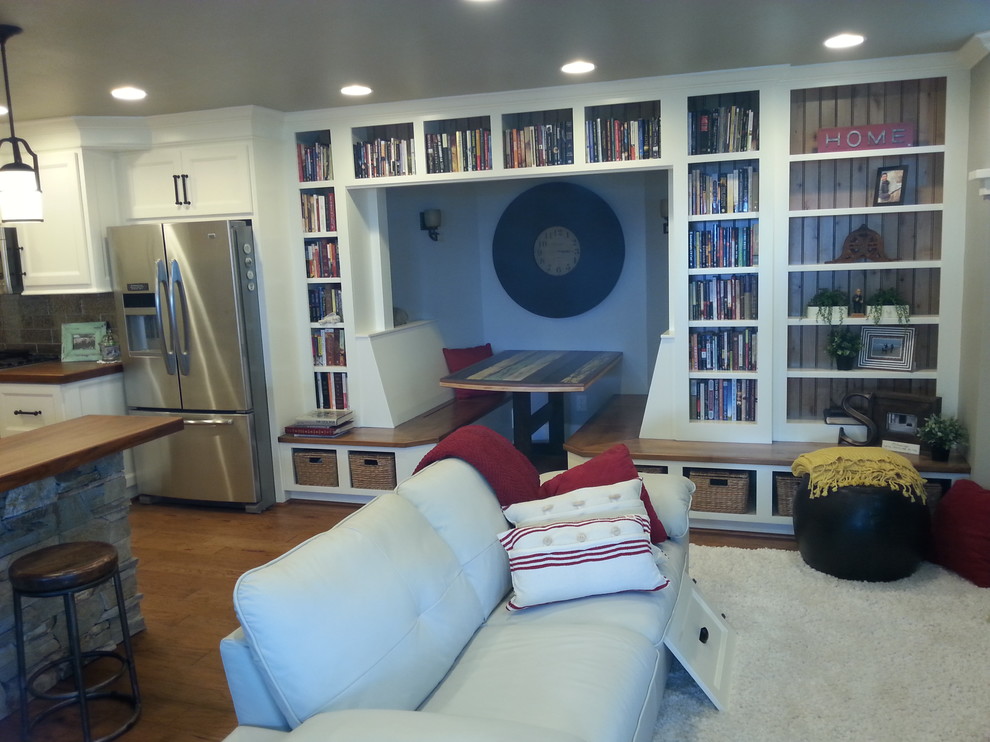 Example of a mid-sized transitional dark wood floor and brown floor great room design with white walls and no fireplace