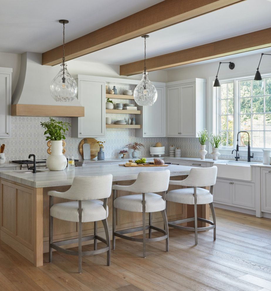 Large transitional kitchen in New York with a farmhouse sink, panelled appliances, medium hardwood floors, with island, brown floor and exposed beam.