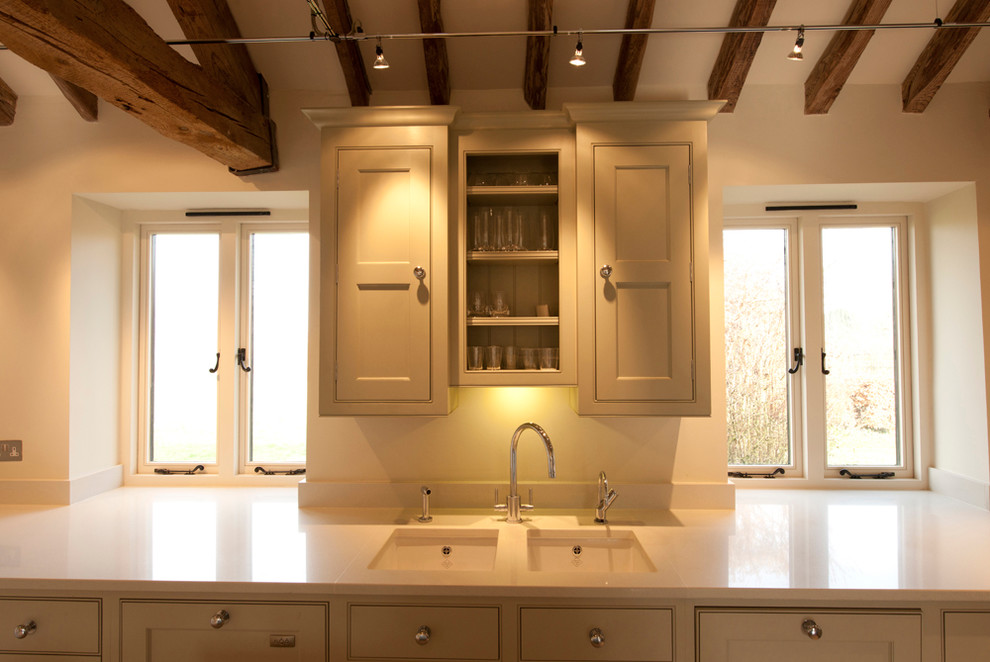 Inspiration for a mid-sized contemporary l-shaped kitchen in Hampshire with an undermount sink, shaker cabinets, beige cabinets, quartz benchtops, metallic splashback, metal splashback, stainless steel appliances, limestone floors and with island.