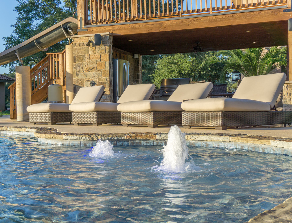 Inspiration for a large rustic backyard stone and custom-shaped water slide remodel in Austin