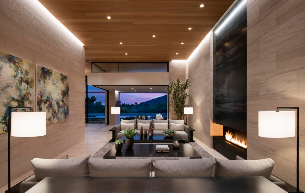 Diseño de salón abierto actual extra grande con suelo de piedra caliza, televisor colgado en la pared, chimenea lineal y piedra