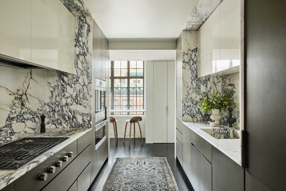 Immagine di una piccola cucina parallela minimalista con lavello sottopiano, ante lisce, ante bianche, elettrodomestici in acciaio inossidabile, parquet scuro e pavimento marrone