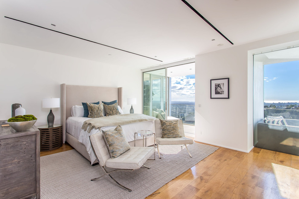 Contemporary master bedroom in Los Angeles with white walls and medium hardwood floors.