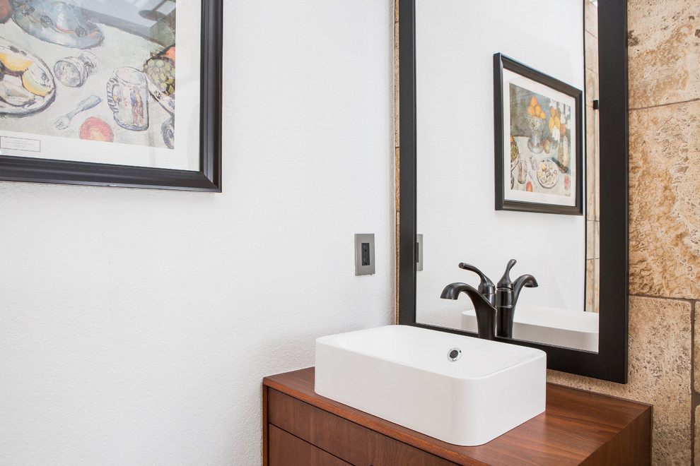This is an example of a mid-sized contemporary 3/4 bathroom in Denver with flat-panel cabinets, dark wood cabinets, an alcove shower, a one-piece toilet, beige tile, travertine, white walls, travertine floors, a vessel sink, wood benchtops, multi-coloured floor, an open shower and brown benchtops.