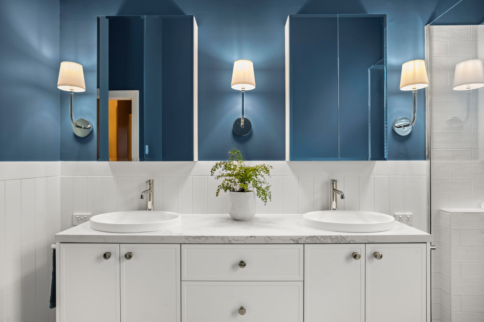 Idée de décoration pour une grande salle de bain tradition avec un placard à porte shaker, des portes de placard blanches, une douche à l'italienne, un mur bleu, un sol en carrelage de porcelaine, un lavabo posé, un plan de toilette en quartz modifié, un sol bleu, une cabine de douche à porte battante, un plan de toilette blanc, meuble double vasque, meuble-lavabo sur pied et du lambris.