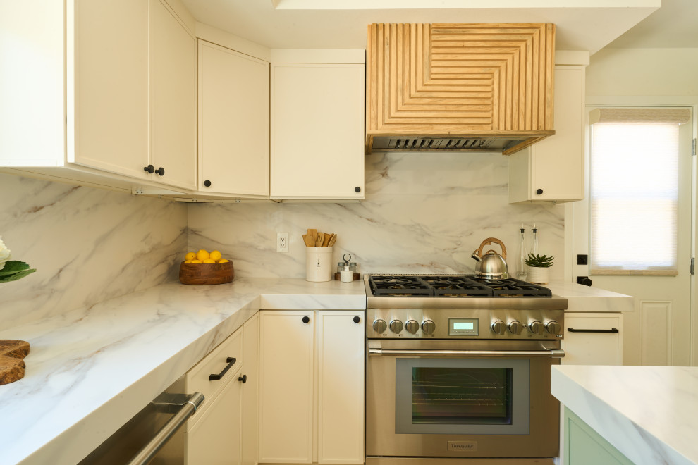 Large transitional u-shaped vinyl floor and brown floor eat-in kitchen photo in Orange County with an undermount sink, shaker cabinets, white cabinets, quartz countertops, white backsplash, quartz backsplash, stainless steel appliances, two islands and white countertops