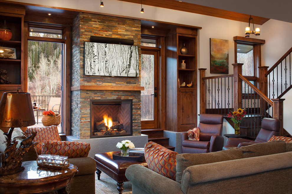 This is an example of a country living room in Denver with a standard fireplace and a stone fireplace surround.
