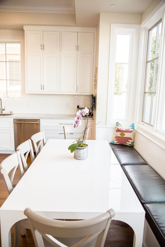 Example of a huge transitional u-shaped porcelain tile and gray floor kitchen design in Los Angeles with an undermount sink, shaker cabinets, white cabinets, quartzite countertops, white backsplash, ceramic backsplash, stainless steel appliances and an island
