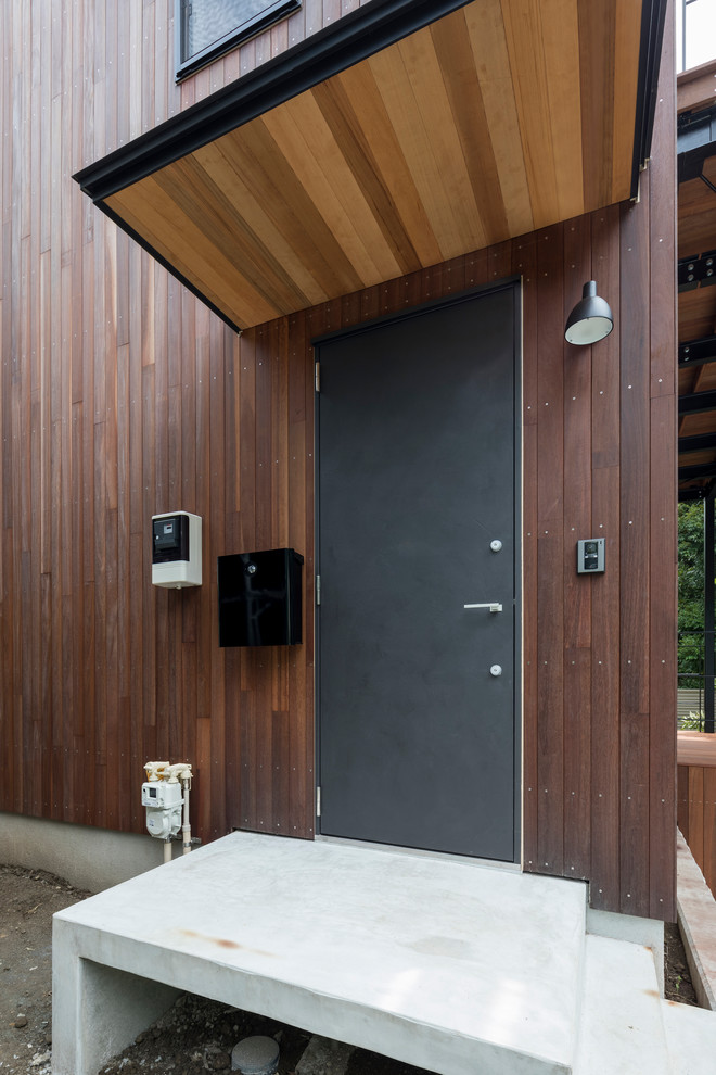 This is an example of a contemporary front door in Other with brown walls, a single front door and a black front door.