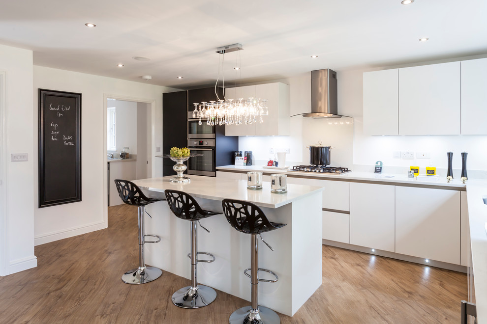 This is an example of a contemporary l-shaped kitchen in Other with flat-panel cabinets, white splashback, light hardwood floors and with island.