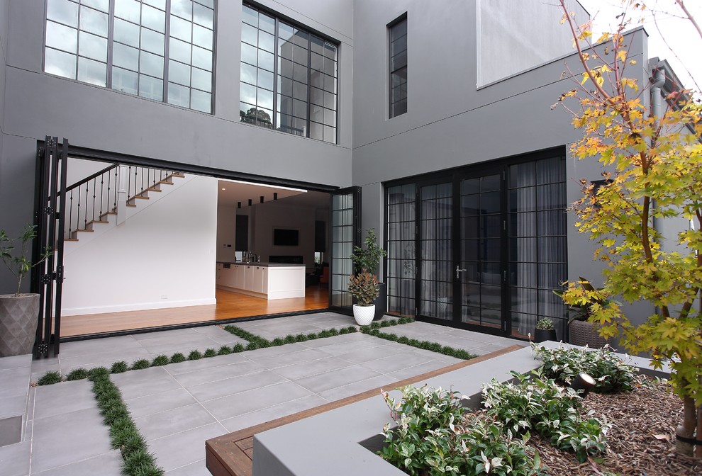 Inspiration for a large contemporary courtyard shaded formal garden for winter in Sydney with natural stone pavers.