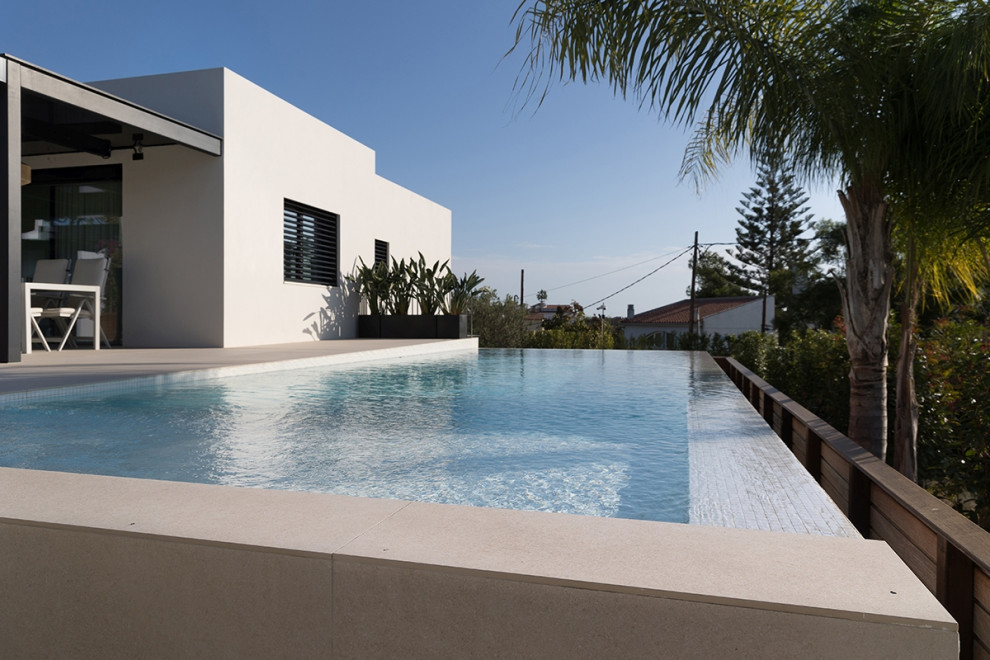 Идея дизайна: большой прямоугольный бассейн на переднем дворе в средиземноморском стиле с покрытием из плитки