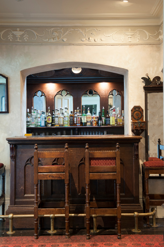 Inspiration for a small traditional single-wall home bar in Other with open cabinets, granite benchtops, mirror splashback, carpet, red floor and brown benchtop.