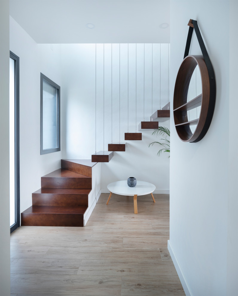 Стильный дизайн: большая угловая лестница в стиле модернизм с деревянными ступенями и перилами из тросов без подступенок - последний тренд