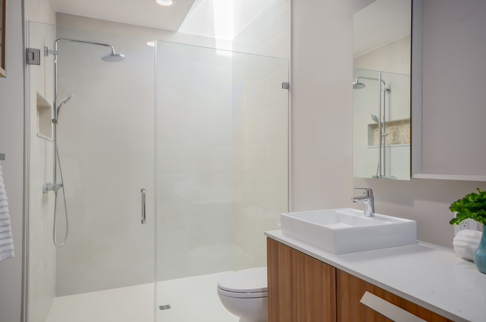 Mid-sized modern bathroom in DC Metro with flat-panel cabinets, light wood cabinets, an alcove shower, a one-piece toilet, white tile, ceramic tile, white walls, a console sink and granite benchtops.