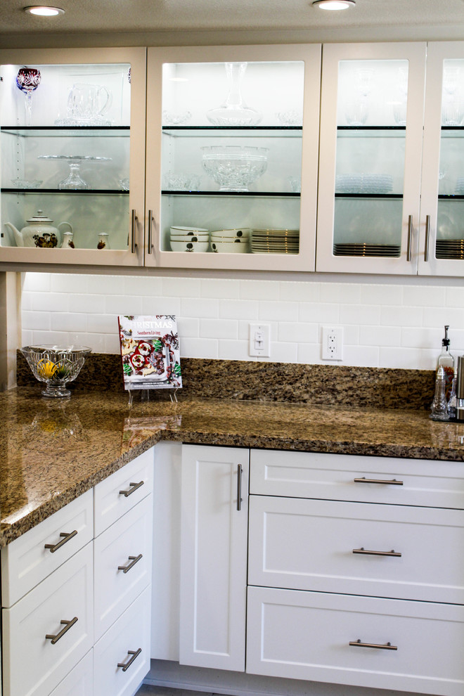 Mid-sized transitional u-shaped porcelain tile and beige floor enclosed kitchen photo with an undermount sink, shaker cabinets, white cabinets, granite countertops, white backsplash, subway tile backsplash, stainless steel appliances, a peninsula and beige countertops