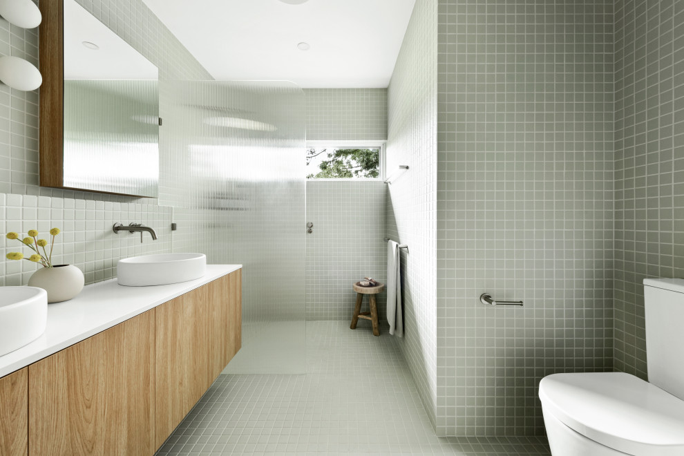 Foto på ett mellanstort vit badrum för barn, med skåp i ljust trä, grön kakel, keramikplattor, gröna väggar, klinkergolv i keramik, grönt golv och med dusch som är öppen