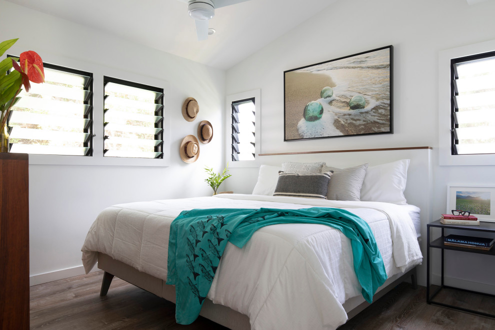 This is an example of a small eclectic master bedroom in Hawaii with white walls, vinyl floors, brown floor, vaulted and wood walls.
