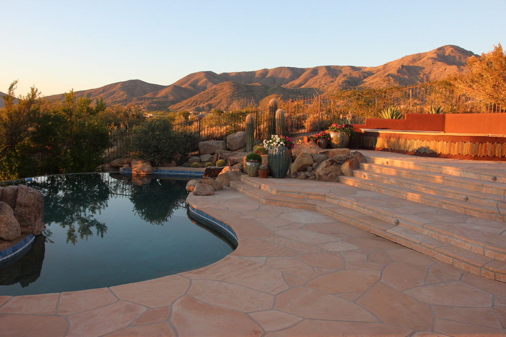 Design ideas for a mediterranean custom-shaped pool in Phoenix with natural stone pavers.