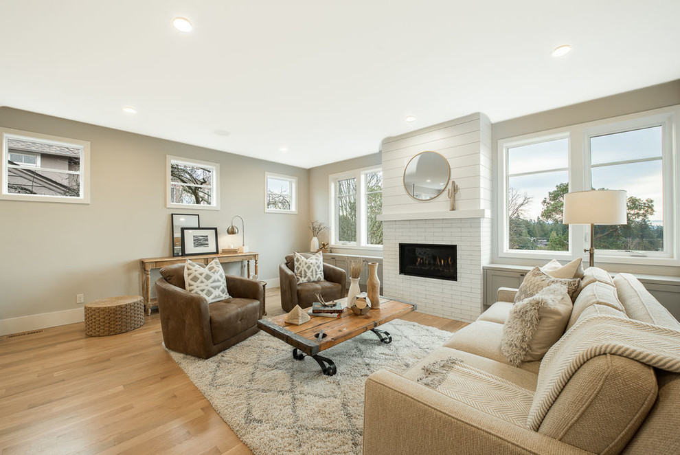 This is an example of a mid-sized transitional formal open concept living room in Seattle with beige walls, light hardwood floors, a standard fireplace, a brick fireplace surround, no tv and beige floor.