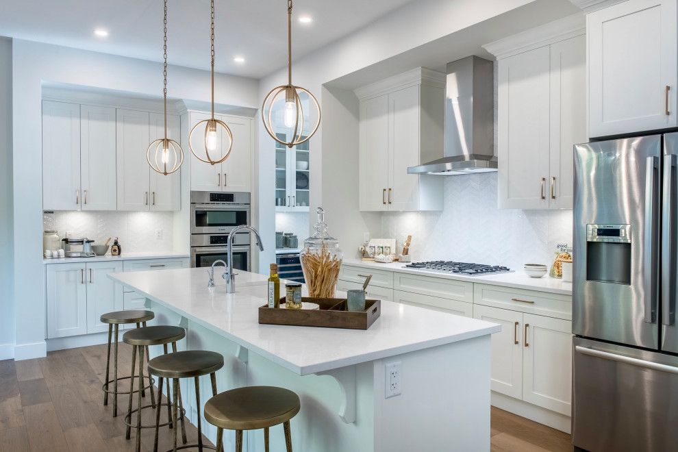 Eat-in kitchen - large transitional l-shaped medium tone wood floor and brown floor eat-in kitchen idea in Vancouver with an undermount sink, white cabinets, white backsplash, stainless steel appliances, an island, recessed-panel cabinets, quartz countertops, porcelain backsplash and white countertops