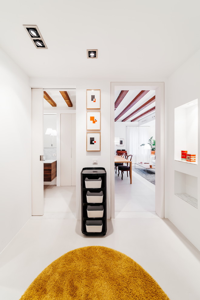 Design ideas for a mid-sized contemporary hallway in Barcelona with white walls, concrete floors and grey floor.