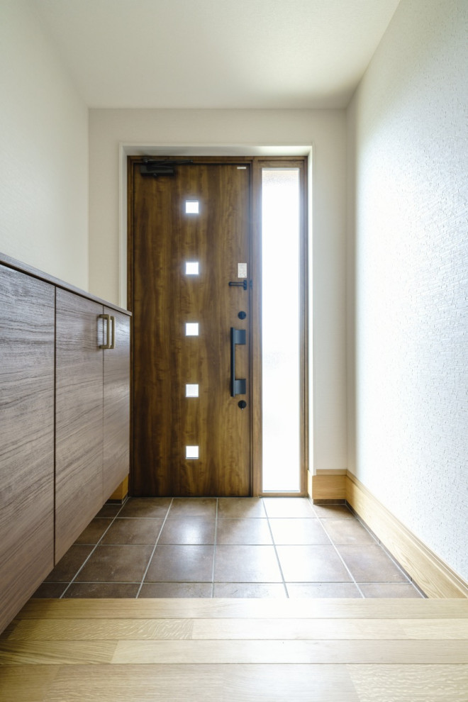 Foto de entrada blanca moderna de tamaño medio con suelo de madera clara, puerta simple, puerta marrón, suelo marrón, papel pintado y papel pintado