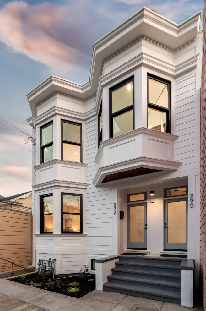 Mittelgroßes, Zweistöckiges Klassisches Haus mit weißer Fassadenfarbe, Flachdach, grauem Dach und Verschalung in San Francisco