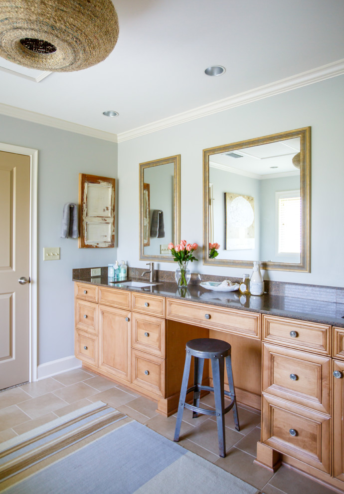This is an example of a mid-sized transitional master bathroom in Jacksonville with raised-panel cabinets, medium wood cabinets, a freestanding tub, a corner shower, grey walls, an undermount sink and granite benchtops.