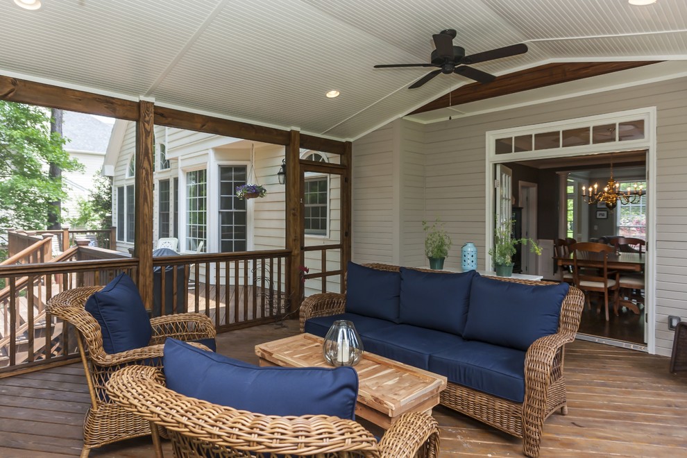 This is an example of a large traditional backyard screened-in verandah in Raleigh with a roof extension.