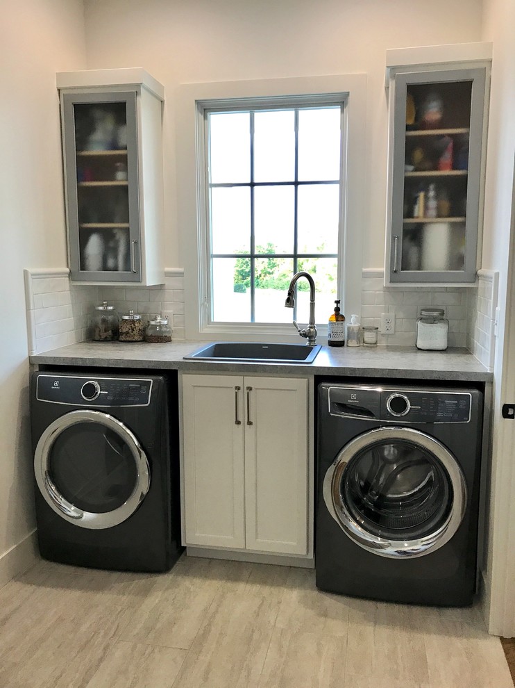 Mid-sized country u-shaped dedicated laundry room in Other with a single-bowl sink, flat-panel cabinets, white cabinets, laminate benchtops, white walls, porcelain floors, a side-by-side washer and dryer and grey floor.