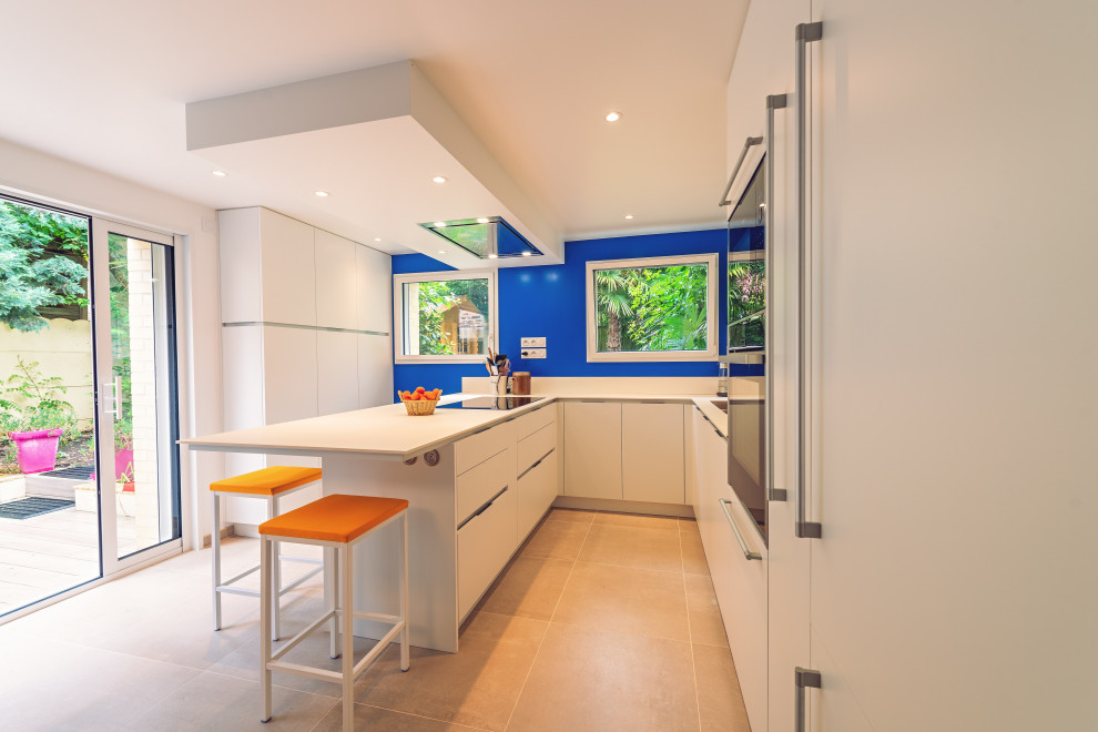 Design ideas for a large contemporary u-shaped open plan kitchen in Rennes with white splashback, stainless steel appliances and ceramic floors.