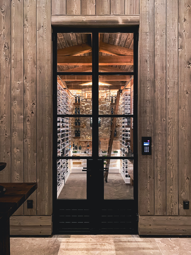 Large industrial wine cellar in San Francisco with brick floors, storage racks and grey floor.