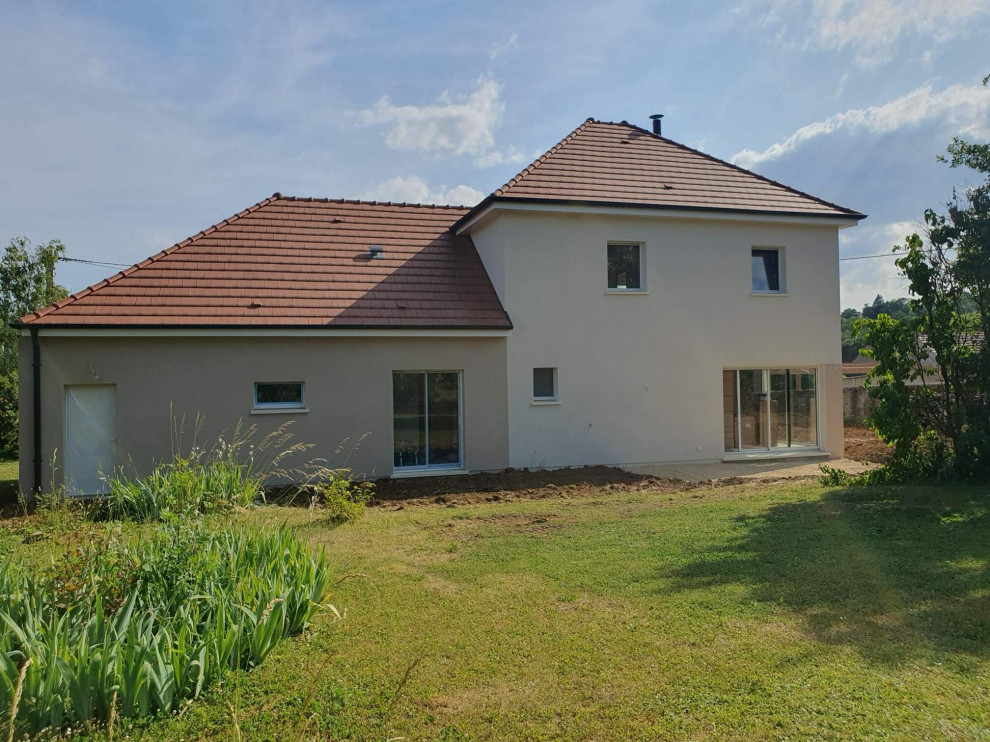 Cette photo montre une façade de maison blanche tendance de taille moyenne et à un étage avec un toit à quatre pans, un toit en tuile et un toit marron.