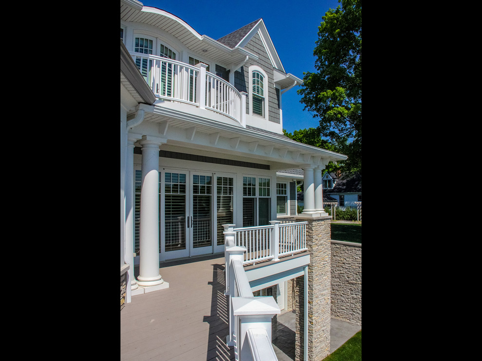 Inspiration for a large coastal three-story concrete fiberboard gray deck remodel with a mixed material roof