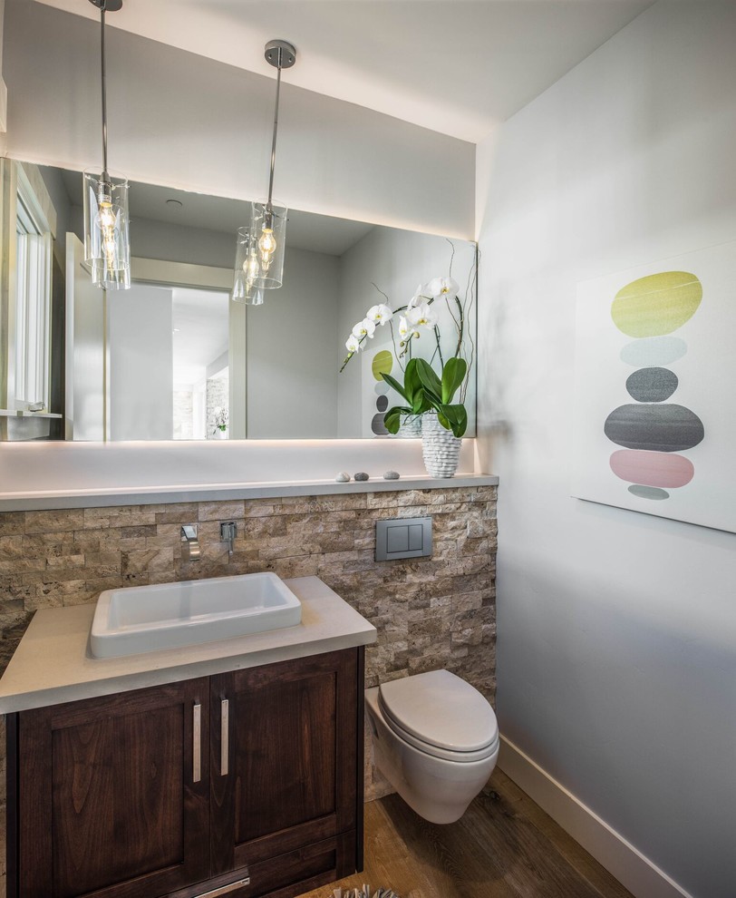 Mid-sized transitional light wood floor bathroom photo in Orange County with shaker cabinets, dark wood cabinets, a wall-mount toilet, gray walls and a vessel sink