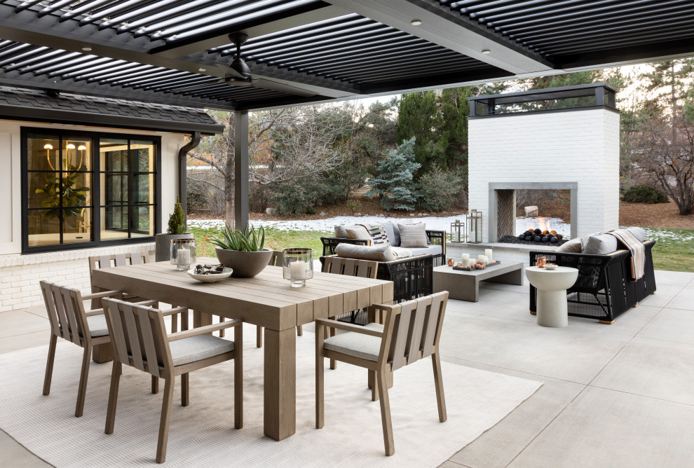 Example of a large transitional backyard concrete paver patio design in Denver with a fireplace and a pergola