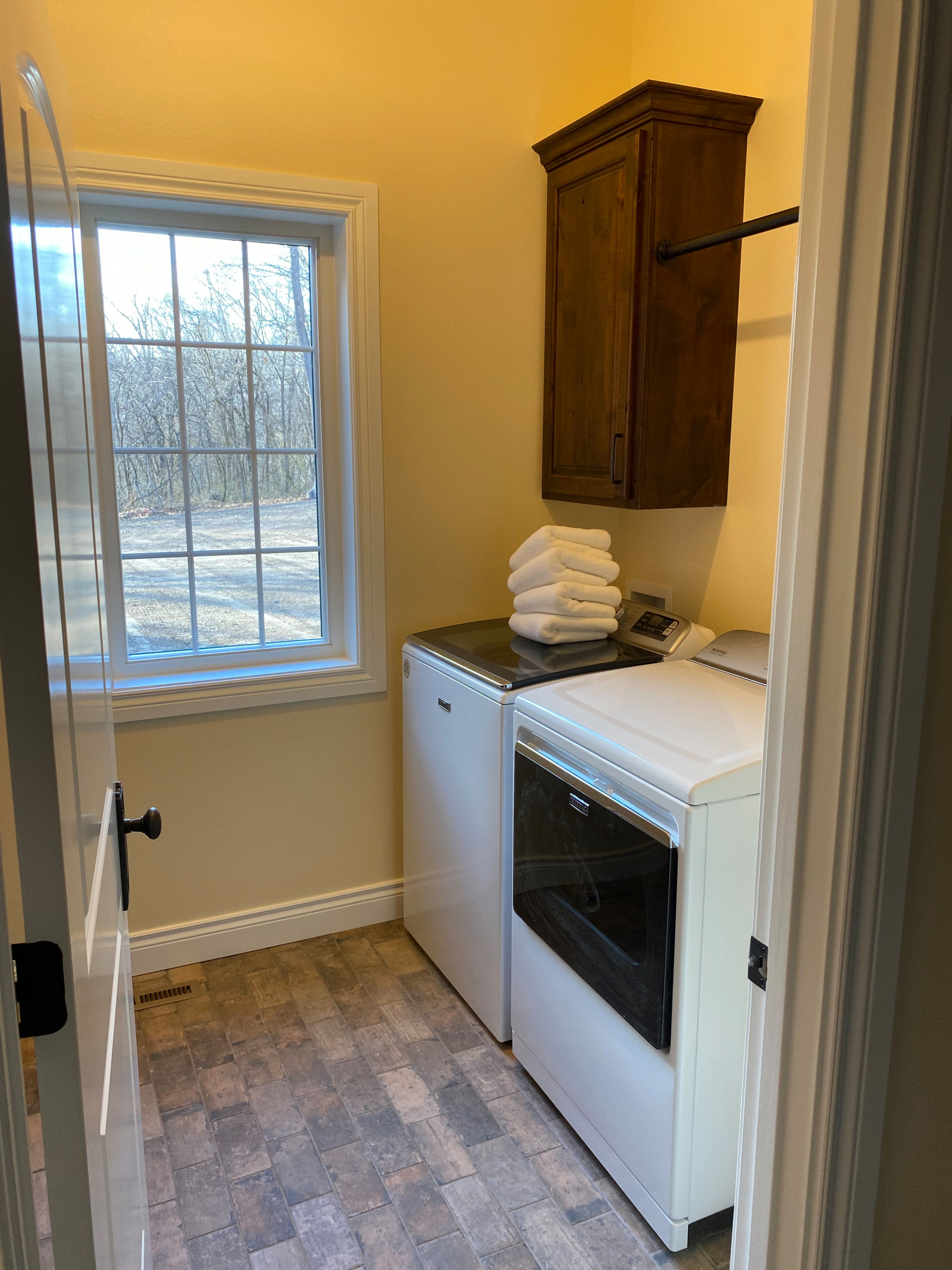 Laundry room with brick tile floor