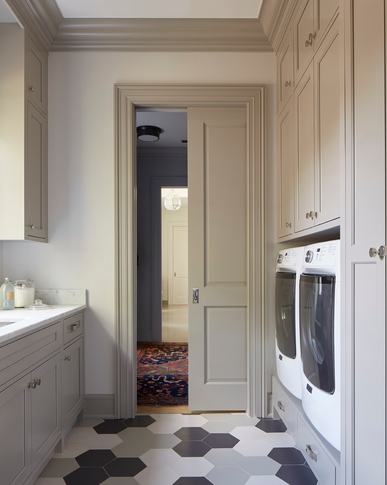 Inspiration for a mid-sized galley dedicated laundry room in Jacksonville with an undermount sink, grey cabinets, marble benchtops, grey walls, porcelain floors, a side-by-side washer and dryer and recessed-panel cabinets.