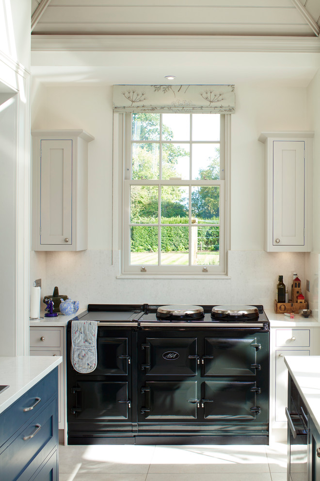 Photo of a traditional u-shaped kitchen in Berkshire with shaker cabinets, blue cabinets, blue splashback, with island and grey floor.