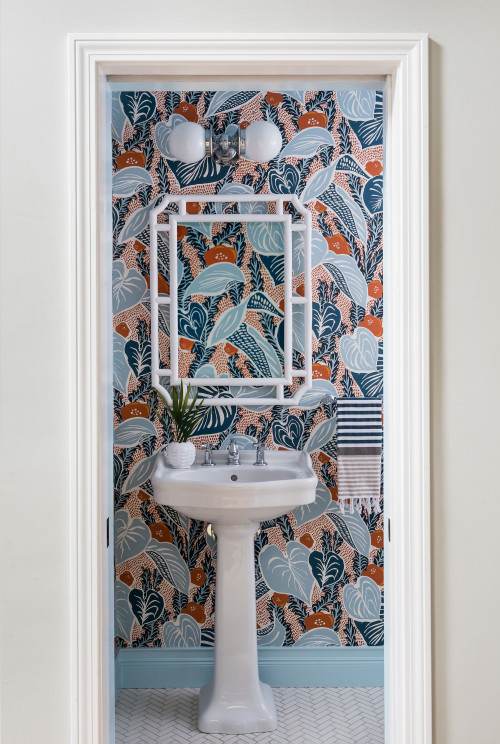 Joyelle West Photography Powder room remodel with a vibrant botanical wallpaper in shades of blue and orange, from Makelike Design, herringbone mosaic tile floor, pedestal sink, and blue painted baseboard molding, crown molding and ceiling.
Example of a small transitional ceramic tile, beige floor and wallpaper powder room design in Boston with a two-piece toilet, multicolored walls and a pedestal sink 