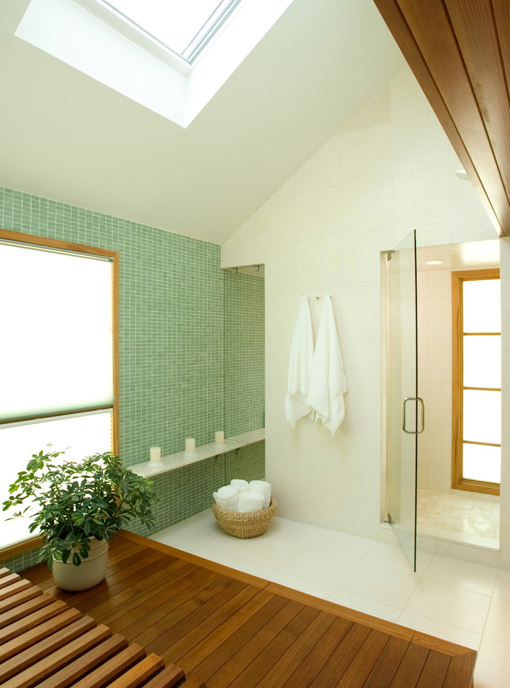 This is an example of a large contemporary master bathroom in Other with flat-panel cabinets, medium wood cabinets, a japanese tub, a corner shower, green tile, mosaic tile, white walls, ceramic floors, white floor and a hinged shower door.