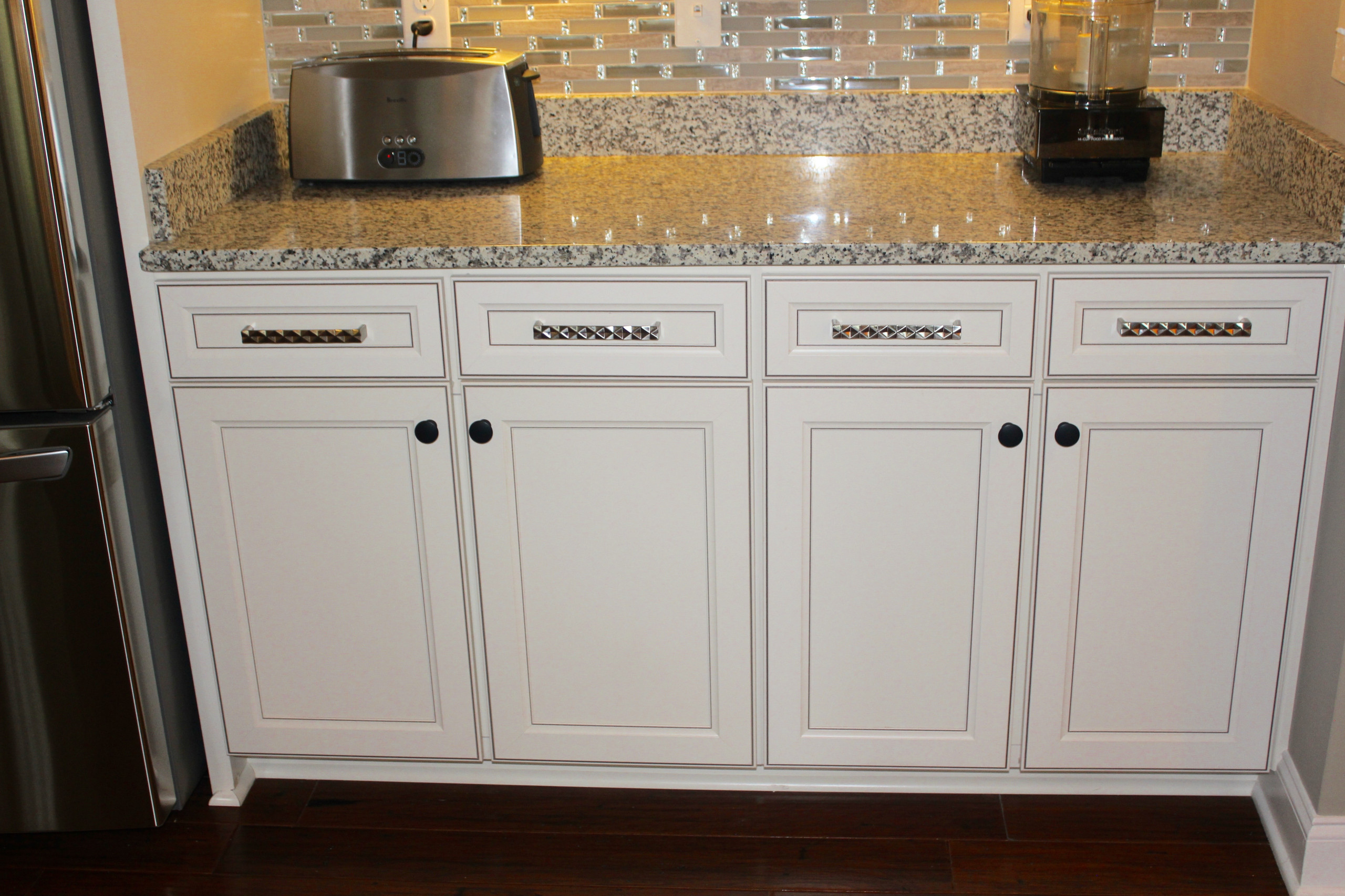 Oversized brushed nickel pulls are combined with black knobs