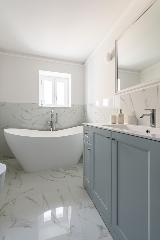 Exempel på ett litet klassiskt vit vitt badrum, med turkosa skåp, ett fristående badkar, en vägghängd toalettstol, vit kakel, marmorkakel, vita väggar och marmorgolv