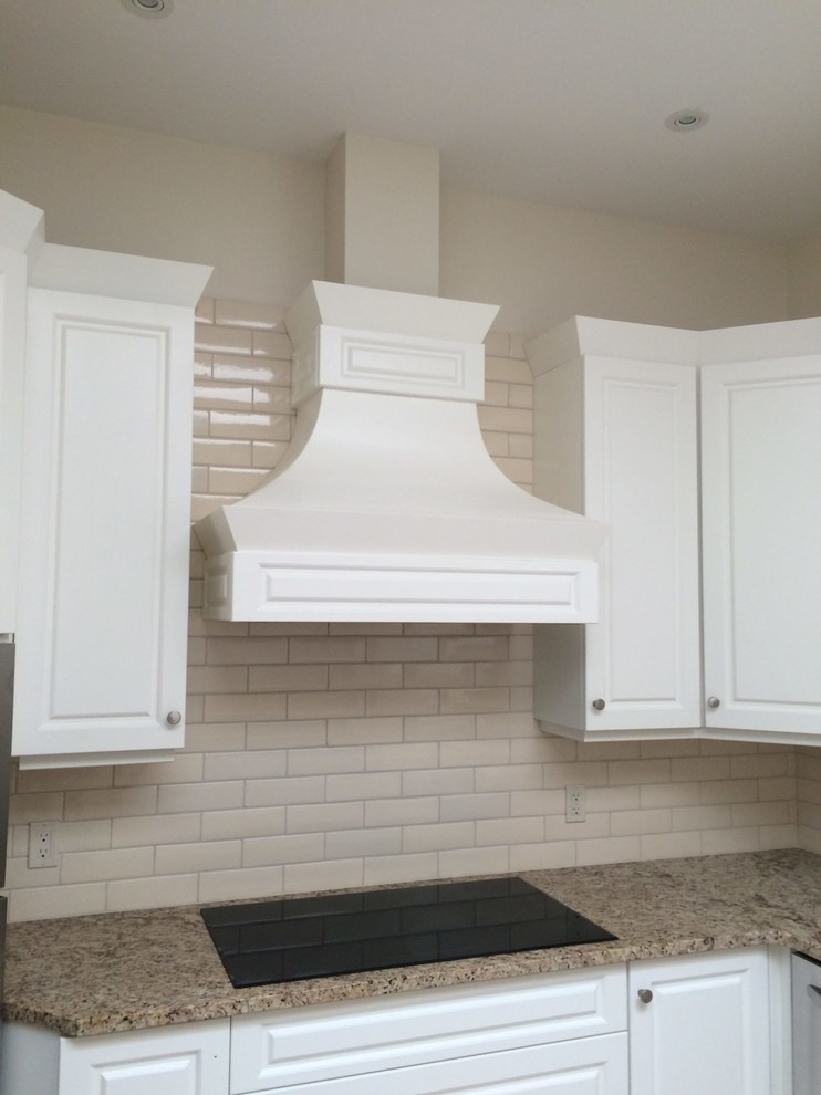 Mid-sized transitional u-shaped eat-in kitchen photo with raised-panel cabinets, white cabinets, granite countertops, beige backsplash, subway tile backsplash, black appliances and multicolored countertops