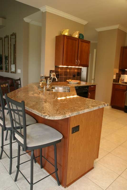 Example of a transitional u-shaped medium tone wood floor kitchen pantry design in Chicago with raised-panel cabinets, medium tone wood cabinets and granite countertops